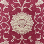 Floral patterned rug with beige flowers on a red background