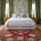 Decorative bedroom with floral wallpaper, bed, and a red asian wool rug.