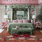 Luxurious bedroom with floral rug, green wallpaper, green canopy bed, and red accents.