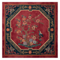 Decorative rug with floral and bird design on a red background