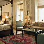 Luxurious living room with ornate furniture and decorative red rug.
